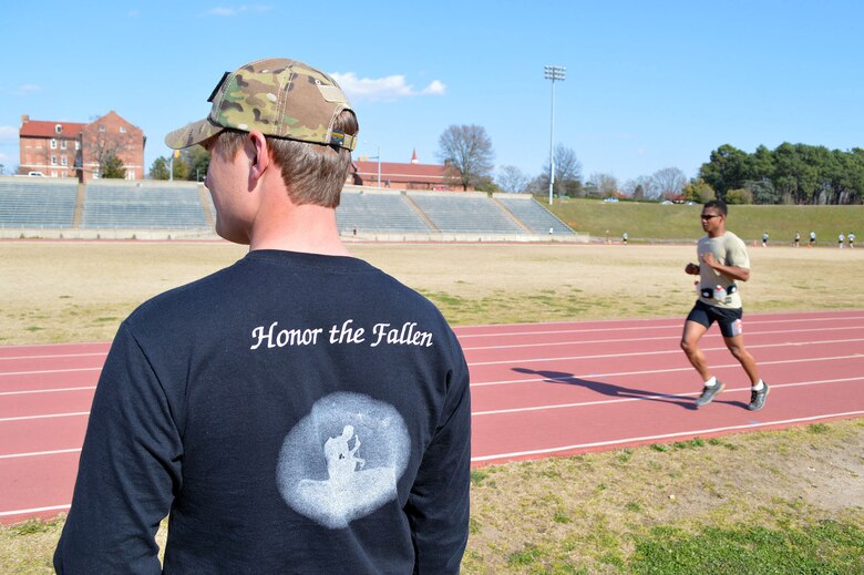 Lt. Chris Brown runs laps at the Hedrick Stadium track during the second annual worldwide TACP 24-hour Challenge Run, March 28-29, while Airman 1st Class Jason Grabe looks on.  Both are TACPs assigned to the 14th Air Support Operations Squadron.  The event is held to honor and raise funds for fallen TACP brothers in arms and their families.  (U.S. Air Force photo by Marvin Krause/Released)