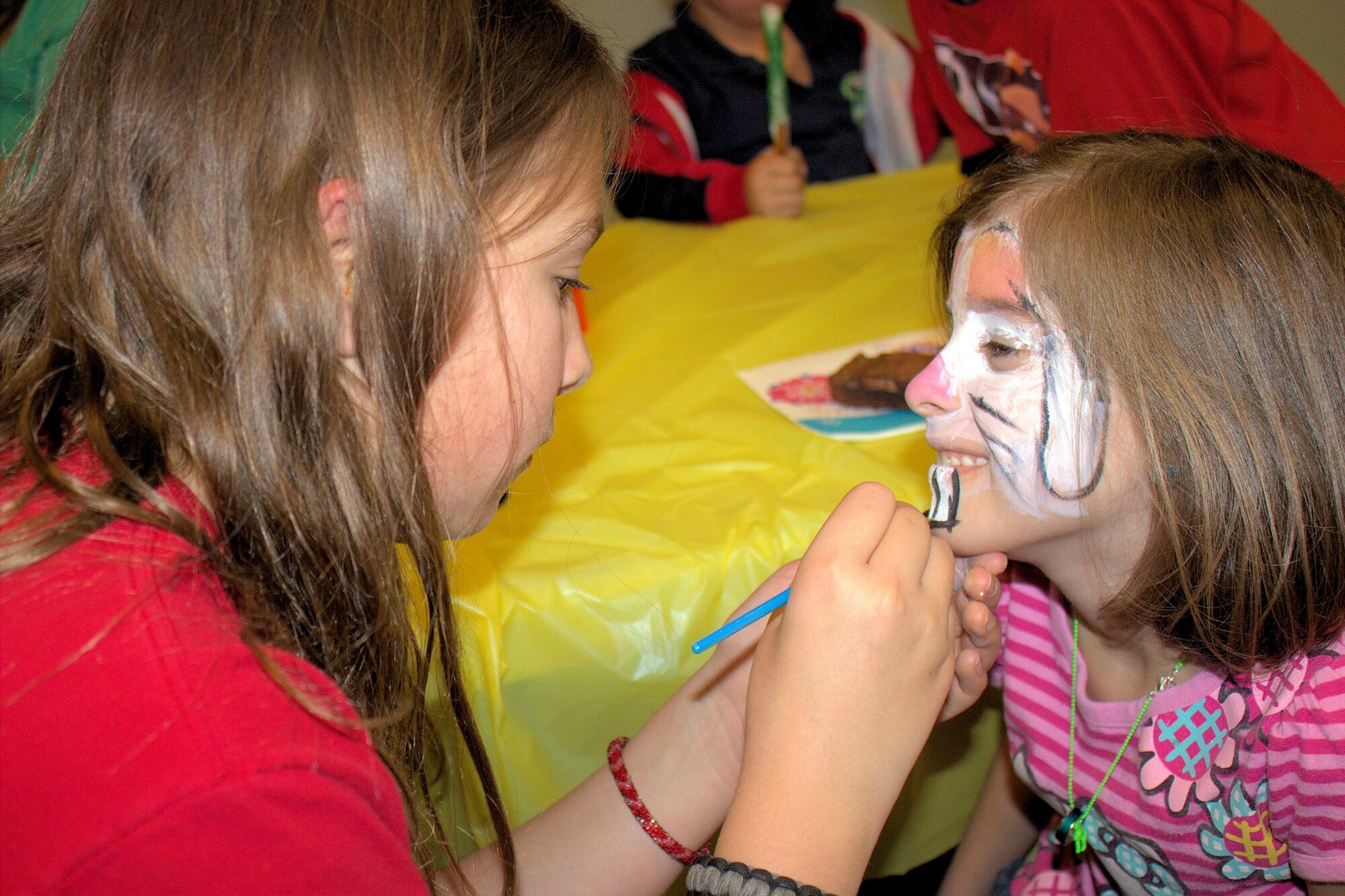 Madison Foster, Torch Club member, paints a child’s face during a Deployed Spouses Dinner March 26, 2013, at Moody Air Force Base, Ga. The event also featured crafts and other activities for children. (Courtesy photo)