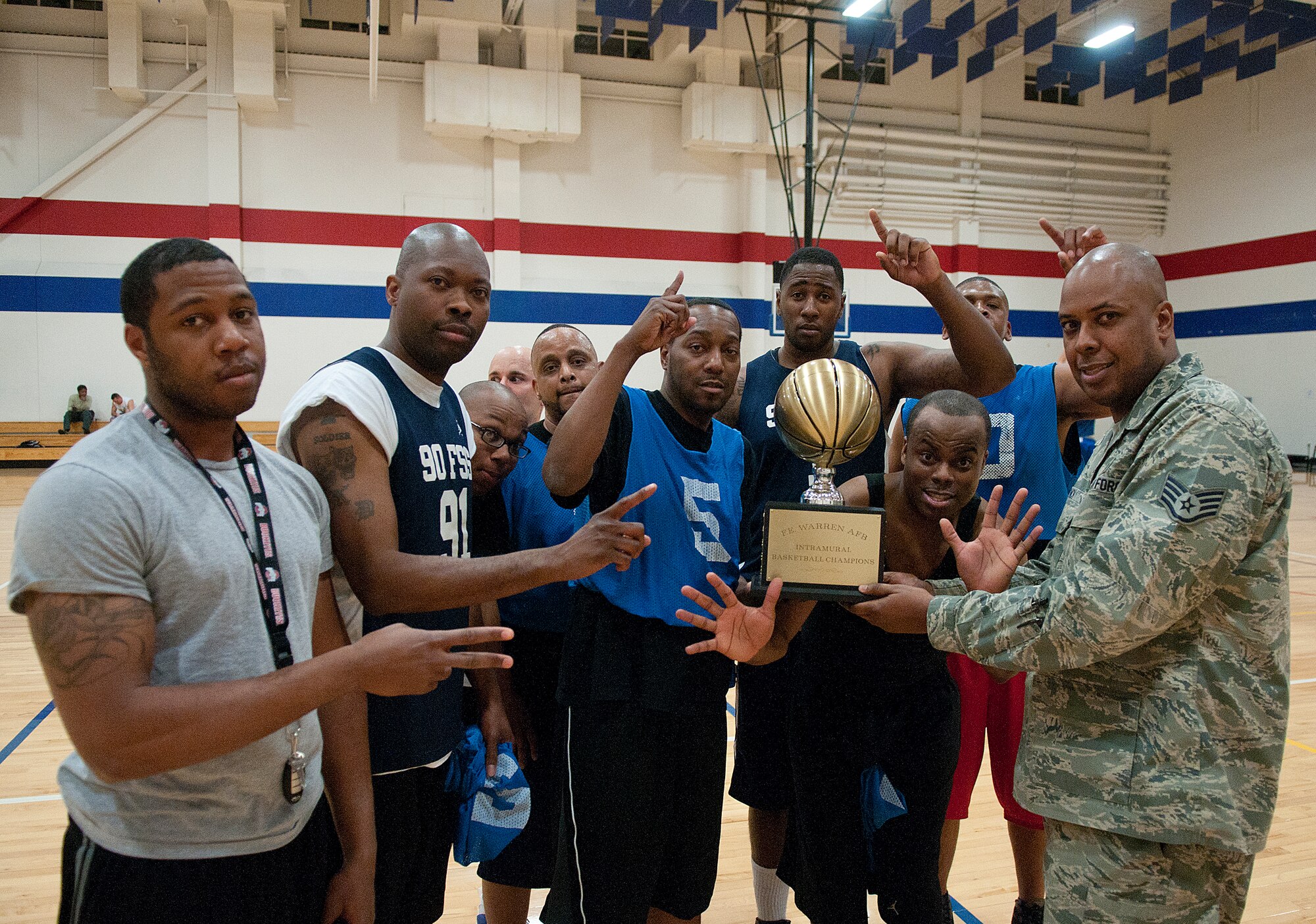 Staff Sgt. Michael Lynch, 90th Force Support Squadron, presents the 90th FSS intramural basketball team with the intramural basketball trophy after they defeated the 90th Operations Group 51 to 50 in the final game of the tournament in the Freedom Hall Fitness Center April 1. (U.S. Air Force photo by R.J. Oriez)