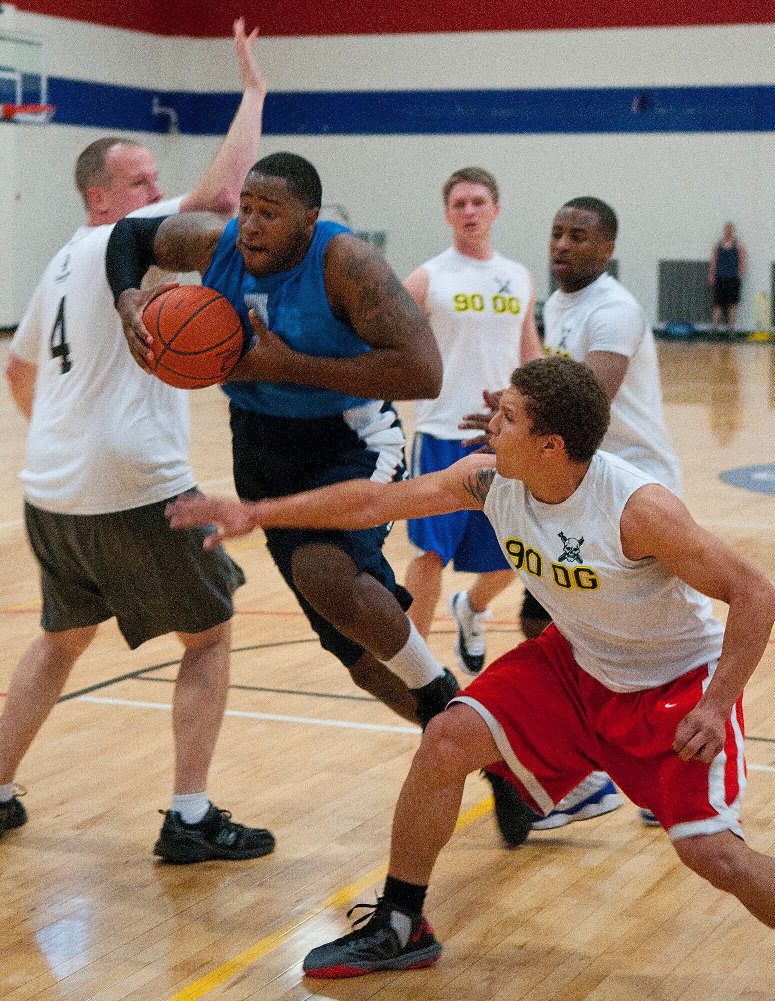 Senior Airman William Shelby of the 90th Force Support Squadron’s intramural basketball team charges past 90th Operations Group defenders to the basket in the Freedom Hall Fitness Center April 1. (U.S. Air Force photo by R.J. Oriez)