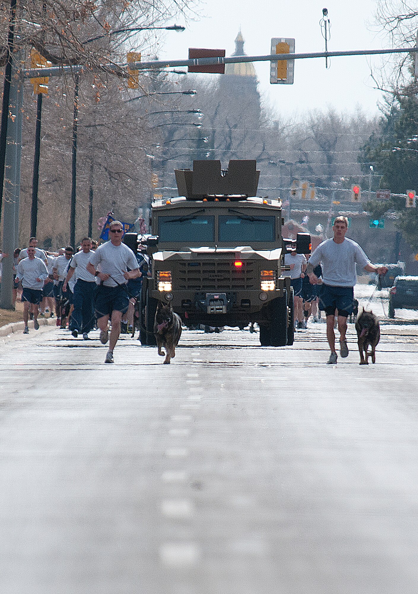 A pair of military working dog handlers and a Bearcat armored vehicle lead the way up Randall Avenue, during the 90th Security Forces Group “pride run” on F. E. Warren Air Force Base March 29. (U.S. Air Force photo by R.J. Oriez) 