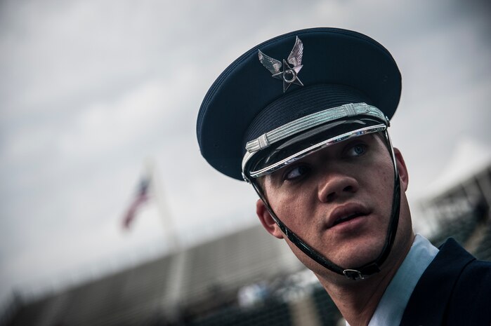 Senior Airman Jaymeson Garvin, Joint Base Charleston Honor Guard member, looks back to make sure his fellow honor guard members were prepared to post the Colors April 3, 2013, at the Family Circle Cup Tennis Tournament in Daniel Island, S.C. A five-member honor guard team posted the Colors and base leaders had the honor of conducting the coin toss prior to the match. (U.S. Air Force photo/ Senior Airman Dennis Sloan)