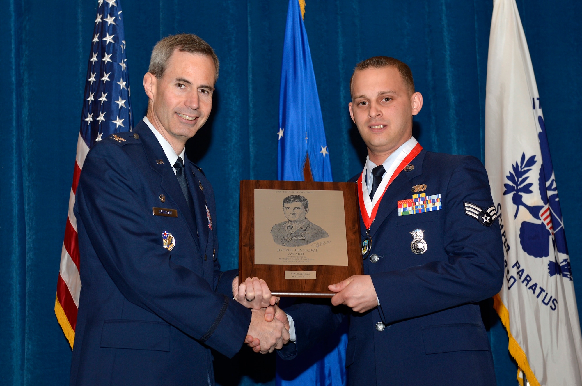 McGHEE TYSON AIR NATIONAL GUARD BASE, Tenn. – Col. Timothy J. Cathcart, commander of the I.G. Brown Training and Education Center here awards Senior Airman Joseph Pico assigned to the 106th Rescue Wing, New York Air National Guard, the John L. Levitow Award, the highest award bestowed for Air Force enlisted professional military education.  Pico and 56 other students graduated from Airman Leadership School April 4 along with 266 Air Force Noncommissioned Officer Academy graduates at the Paul H. Lankford EPME Center.  (National Guard photo by Master Sgt. Kurt Skoglund)