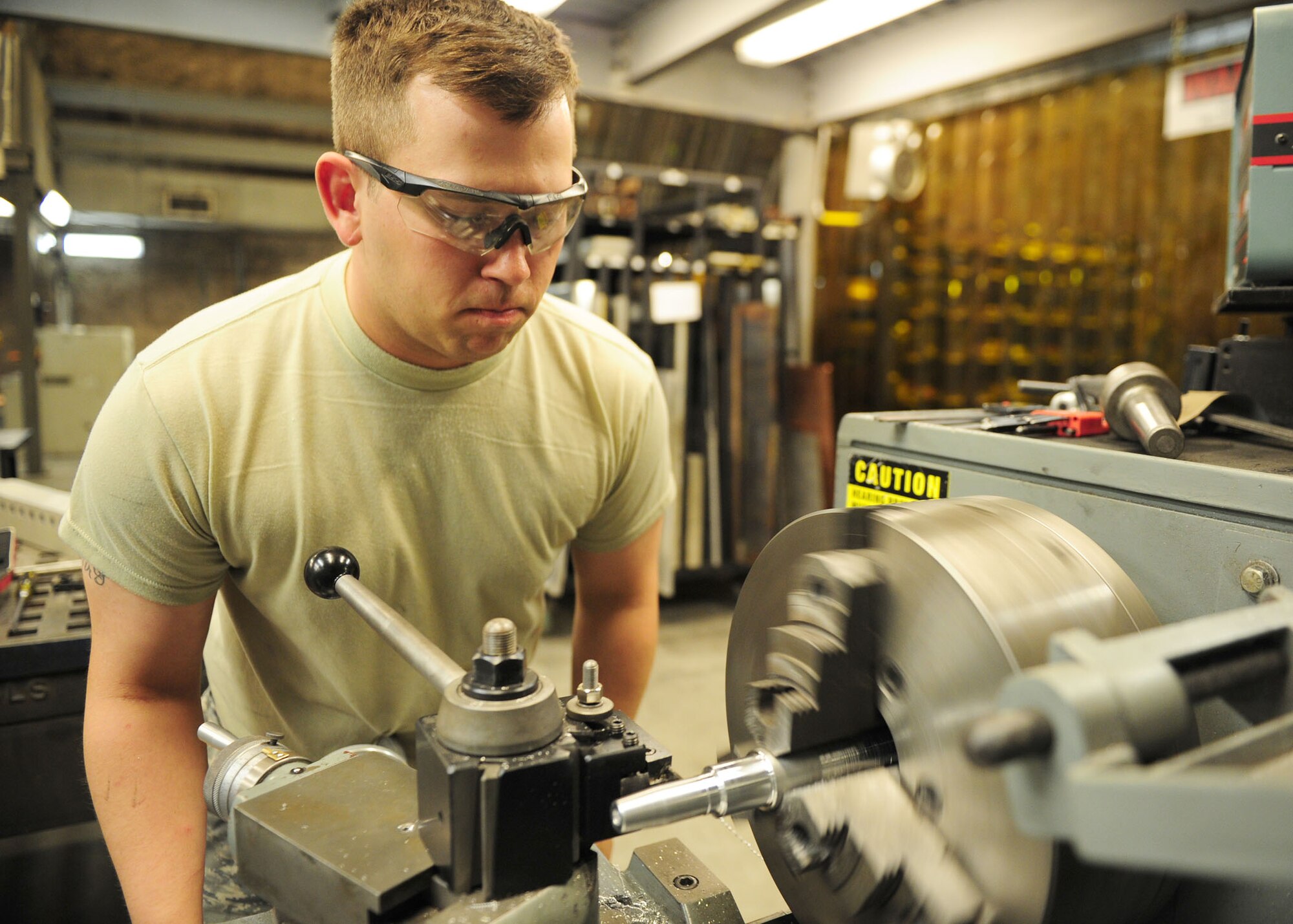 SOUTHWEST ASIA -- Senior Airman Elliot Sandahl, a metals technology journeyman from the 379th Expeditionary Aircraft Maintenance Squadron Aircraft Metals Technology Shop, turns a new handle for a drill press on a lathe. Known as Metals Shop, the mission is to support aircraft and air ground equipment with skills in metal work; the only shop capable of working and welding exotic metals such as titanium, cobalt and nickel alloy. Metals shop also fabricates aircraft parts and metal objects that no longer exist in supply inventory, thus keeping aircraft flying. (U.S. Air Force photo/Master Sgt. Brendan Kavanaugh)