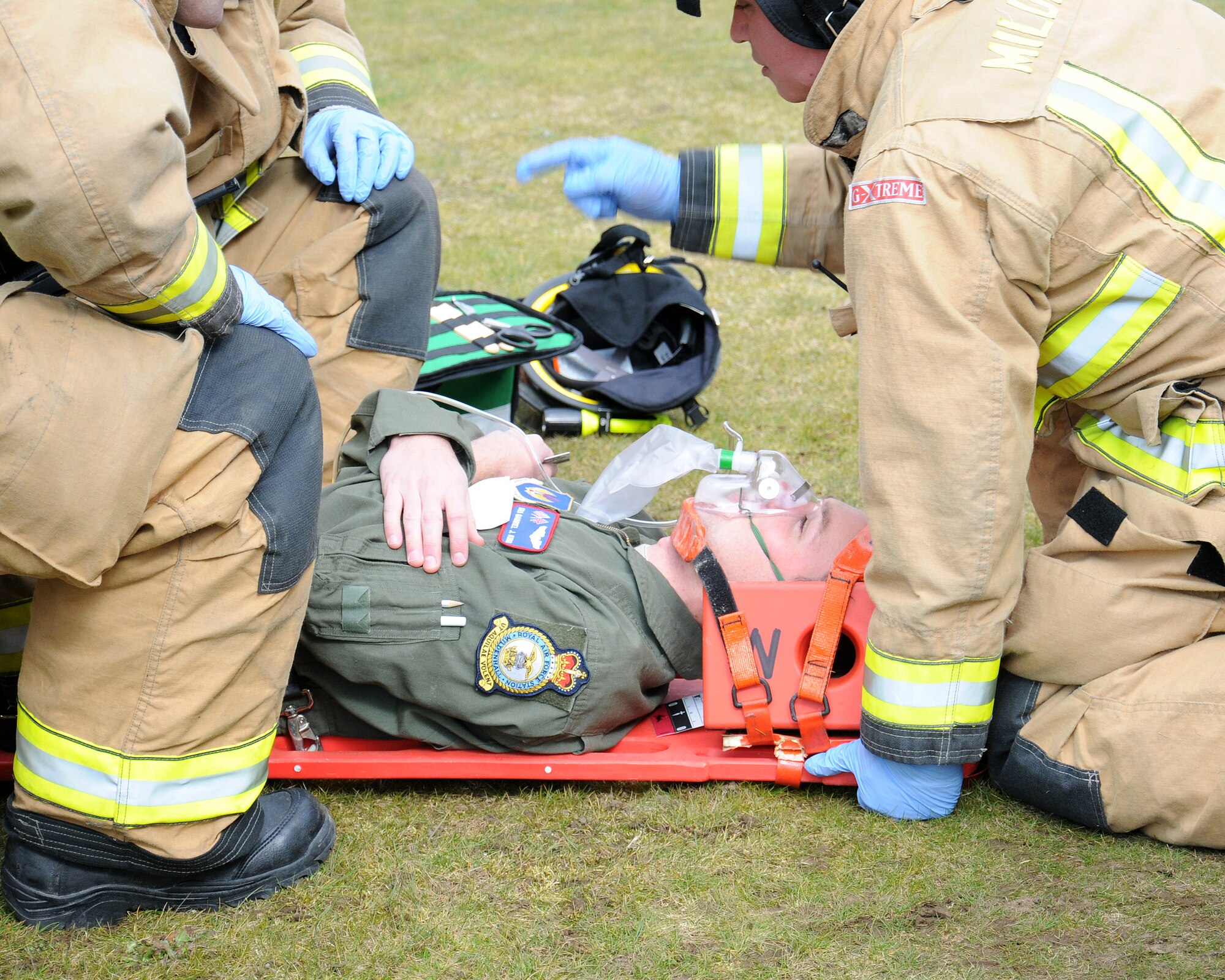 Firefighters from the 100th Civil Engineer Squadron Fire Department prepare to move a simulated patient to an ambulance during an exercise March 28, 2013, at RAF Mildenhall, England. The 100th CES firefighters gave the patient oxygen and they immobilized and packaged him prior to placing him on the ambulance and transporting him to an emergency medical facility. (U.S. Air Force photo by Gina Randall/Released)