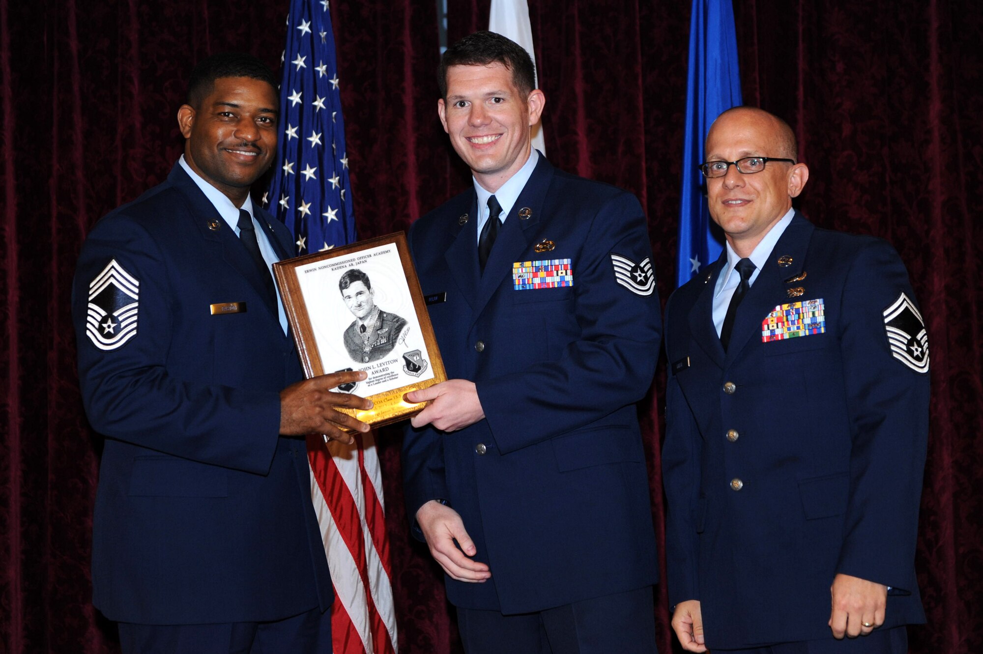 U.S. Air Force Tech. Sgt. James Nolan, 301st Intelligence Squadron, Andersen Air Base, Guam, receives the John L. Levitow award during the NCO Academy Class 13-3 graduation at the Rocker NCO Club on Kadena Air Base, Japan, April 4, 2013. The award, named after Medal of Honor recipient John L. Levitow, is presented to the most outstanding member of the class and denotes superior achievement as both a leader and a scholar. (U.S. Air Force photo by Airman 1st Class Hailey R. Davis/Released)