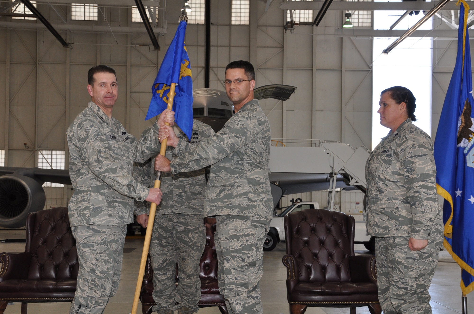 Maj. John Schloss, Commander, 931st Maintenance Squadron, receives the unit flag from Lt. Col. Christopher Labrum, 931st Air Refueling Group Deputy Commander for Maintenance during a change of command ceremony at McConnell Air Force Base, Kansas, April 6. Schloss takes over for Lt. Col. Sherry Teague (right), who led the unit since its activation in October 2009. (Air Force photo by Master Sgt. Brannen Parrish)
