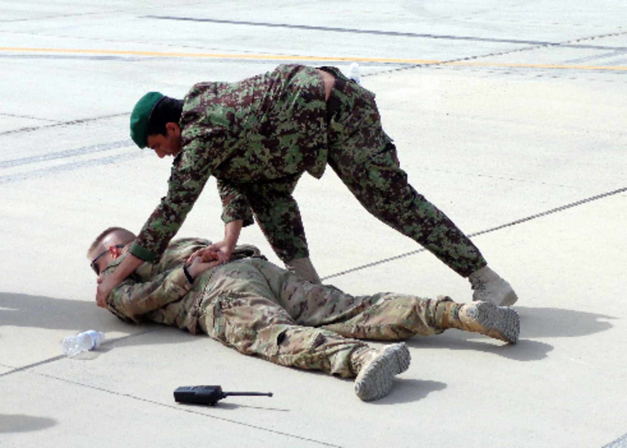 United States Air Force Master Sgt. Chad Roberts, 738th Air Expeditionary Advisory Group security forces advisor, allows himself to be restrained and searched as part of a class at Kandahar Airfield, Afghanistan. AAF members with KAW security forces underwent training in order to assume flightline security responsibilities. Advisors with NATO Air Training Command-Afghanistan developed and lead the six-day training course for 15 AAF security forces members to include both classroom and hands-on instruction. (courtesy photo)