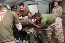 Corpsmen with 3rd Medical Bn. roll a simulated casualty onto a stretcher during the forward resuscitative care course March 28 at Camp Foster. 