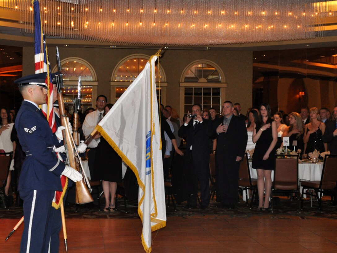 Approximately 400 members and their families stand with hands over their hearts while the national anthem is sung and the honor guard stands at attention during the annual awards banquet. Members of the 104th Fighter Wing celebrated the accomplishments of their peers at the 39th annual awards banquet held at the Sheraton Hotel, Springfield, Mass., April 6, 2013. (Air National Guard photo by Maj. Mary Harrington)