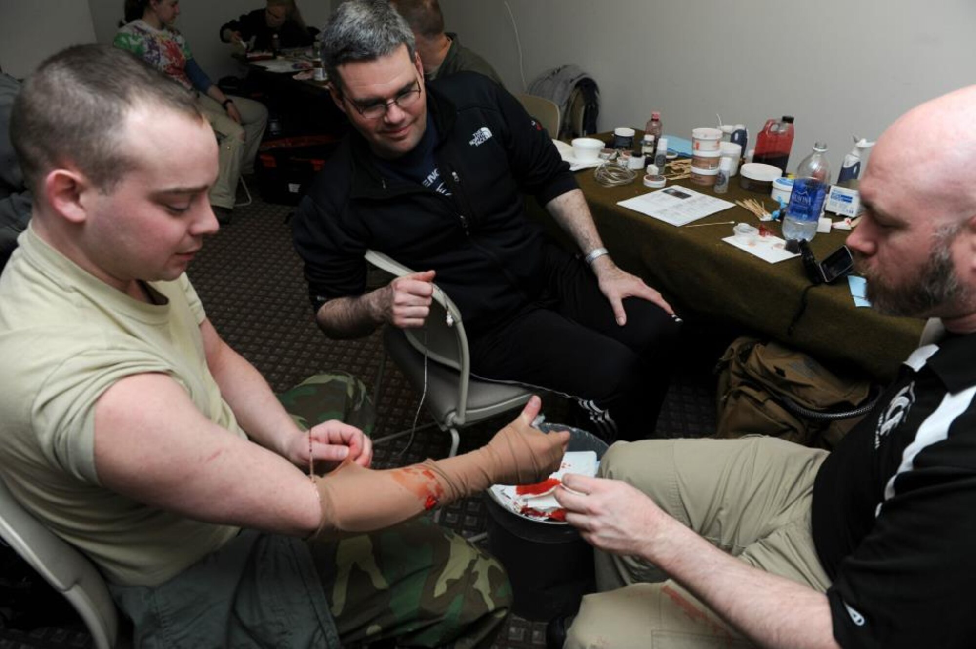 Master Sgt. Micheal Karl, and Will Enfinger, members of the 673d Medical Group, apply moulage to Senior Airman Micheal Pollard, an Airman with the 673d Medical Support Squadron on Joint Base Elmendorf-Richardson, April 7, 2013. JBER Airmen are participating in exercise Polar Force 13-3 through April 8. (U.S. Air Force Photo/Airman 1st Class Omari Bernard)