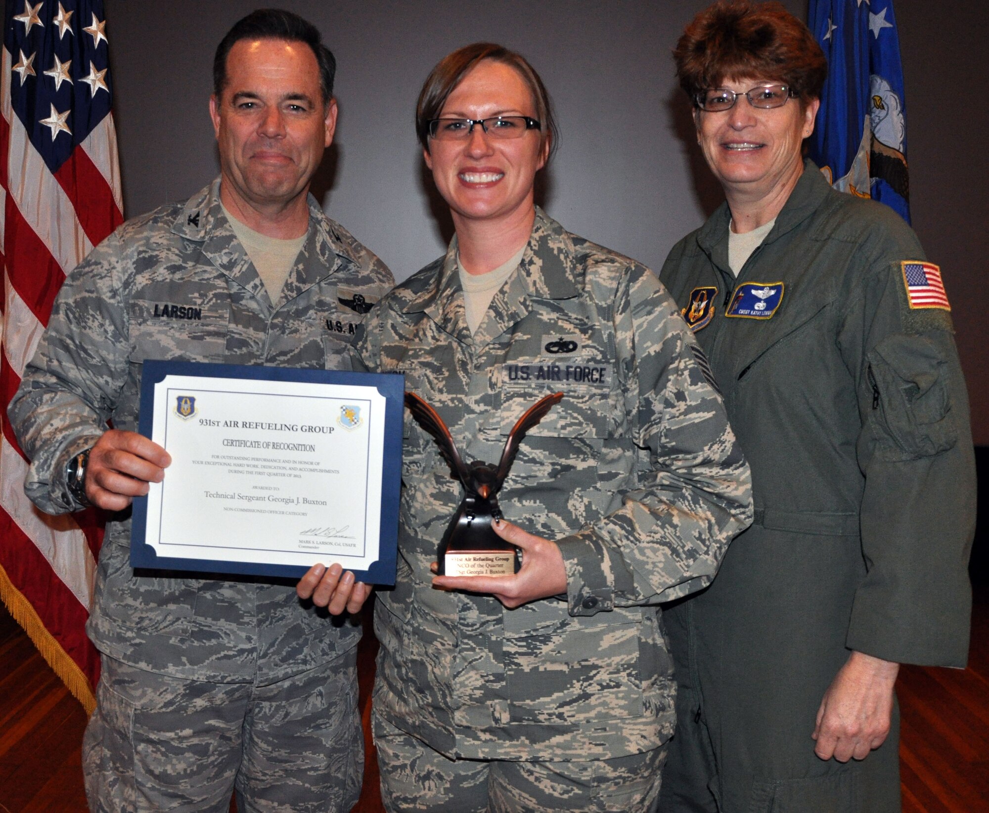 Col. Mark S. Larson, commander of the 931st Air Refueling Group, McConnell Air Force Base, Kan., and Chief Master Sgt. Kathleen E. Lowman, 931st Air Refueling Group Superintendent, present the Noncommissioned Officer of the Quarter award to Tech. Sgt. Georgia Buxton during the 931 ARG commander's call, April 7, 2013.  (U.S. Air Force photo by 1st Lt. Zach Anderson)