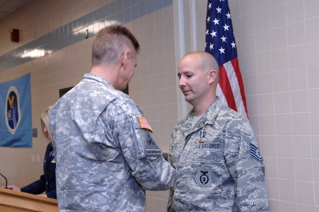 Major General Jefferson S. Burton awards Tech Sgt. Mike Paletta the Utah Cross April 6.  Paletta, a Utah Air National Guardsman from the 151st Security Forces Squadron, was awarded the medal for heroism, distinguishing himself by performing CPR to save the life of a driver who had suffered a heart attack.