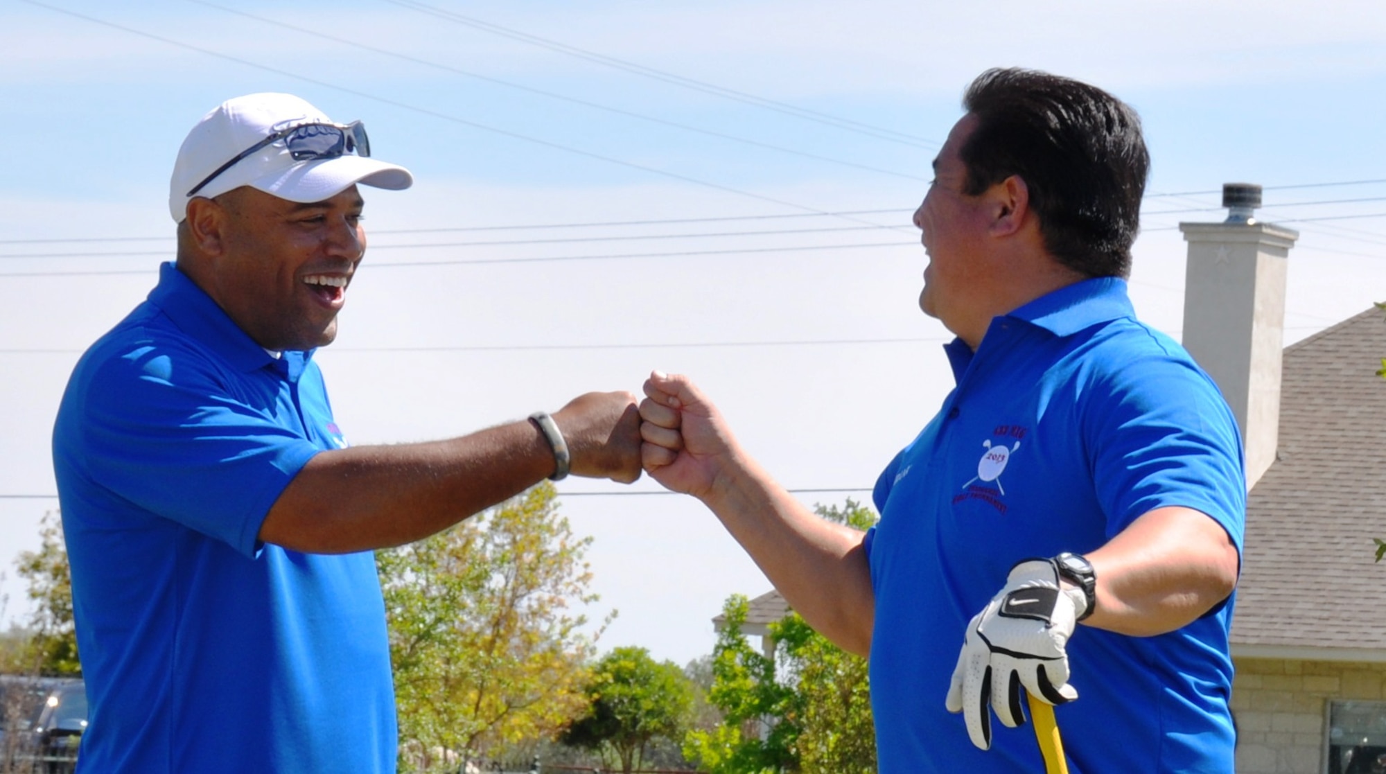 Master Sgt. Robert Millan,433rd Maintenance Operations Squadron, fist bumps team mate Frank Guzman, a 433rd MOS civilian, after a great drive during the Inaugural MXG Golf Tournament held April 5 at the Alsatian Golf Club in Castroville, Texas. The event  raised over $1,300 to help family members of whose loved ones are deployed.  (U.S. Air Force Photo by Tech Sgt. Carlos Trevino)