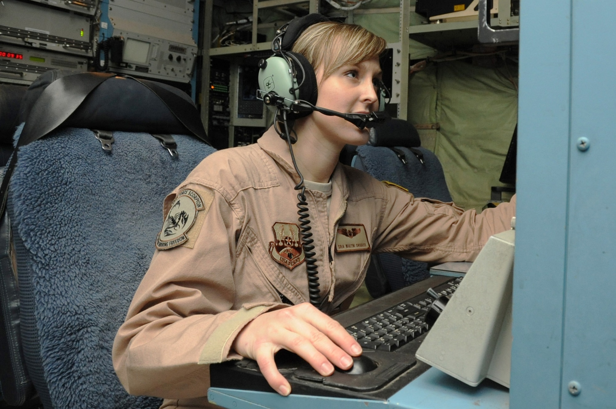 Senior Airman Whitni Orgass, 41st Expeditionary Electronic Combat Squadron cryptological language analyst, works at her station aboard an EC-130 Compass Call aircraft on Bagram Airfield, Afghanistan, March 23, 2013. The 41st EECS flies nightly missions in support of troops on the ground. (U.S. Air Force photo/Staff Sgt. David Dobrydney)