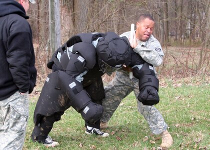 Sgt. 1st Class Antivone Young, 1729 Field Support Maintenance Co., takes down a simulated rioter while fighting the effects of pepper spray.