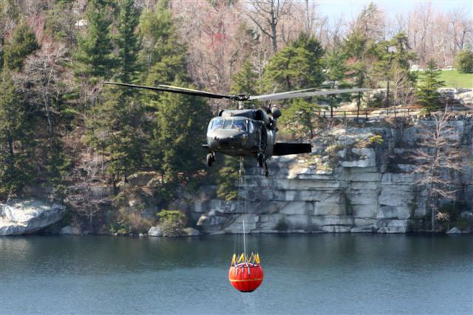A New York Army National Guard UH-60 Black Hawk fills a 600-gallon "Bambi Bucket" from Lake Awosting in Minnewaska State Park, Ulster County, N.Y., April 21, prior to making another dump on a 3,100 acre wildfire. Army National Guard aviation assets responded to a State Emergency Management Office request for assistance on Saturday, April 19, when one Black Hawk helicopter flew 37 water dump missions. On Sunday April 20, and Monday April 21, two Black Hawks responded, flying 14 water missions each day. A New York Army National Guard OH-58 recon helicopter equipped with a thermal imaging device was also used to identify fire hot spots for targeted drops.