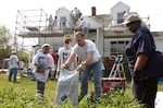 Airmen, Soldiers and civilians with the National Guard repair the home of Michelle Samuel April 26 in LaPlata, Md., during "National Rebuilding Day." The Guard volunteers shingled her roof, repainted the interior and exterior, installed a new stove, washer and dryer, repaired the ceilings and bathroom, installed a new storm door and made many other repairs at no cost.