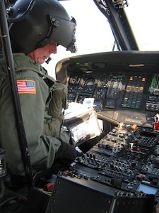 Col. Charles H. Schulze, Maryland's state Army aviation and aviation training officer, checks a system on a new multi-band radio before a training flight. Maryland Guard pilots are leaning to use the new radio which enables them to communicate with local first responders on the ground during an emergency.