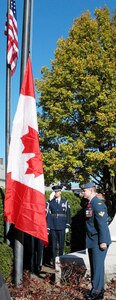 Master Sgt. Thomas Whiteman, an Air National Guardsman with Northeast Air Defense Sector, salutes as Master Cpl. Bob Peldjak, a Canadian member of NEADS, stands at attention while the Canadian national anthem is played and the Canadian flag is raised on Veterans Day, Nov. 11, 2007. The binational, joint ceremony is held every year at the Veterans Memorial Park in Rome, N.Y., honoring the sacrifices veterans have made for both countries.