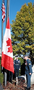 Master Sgt. Thomas Whiteman, an Air National Guardsman with Northeast Air Defense Sector, salutes as Master Cpl. Bob Peldjak, a Canadian member of NEADS, stands at attention while the Canadian national anthem is played and the Canadian flag is raised on Veterans Day, Nov. 11, 2007. The binational, joint ceremony is held every year at the Veterans Memorial Park in Rome, N.Y., honoring the sacrifices veterans have made for both countries.