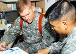 Army Maj. Barry Hafer, left, a Marshall, Texas, native, helps review population perception while going over plans with Army Maj. Keith Chinn, an Elk Grove, Calif., native, at Camp Liberty, Iraq, May 10, 2008. Hafer, a member of 5th Battalion, 112th Artillery Regiment, 36th Infantry Division, Texas Army National Guard, is attached to 4th Infantry Division, Multinational Division Baghdad, and is serving as the division's Red Team leader. Chinn is an operations analyst in the division plans shop.