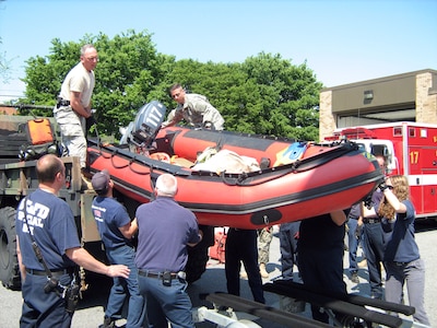 Spc. Bob Walker (left) and Sgt. George C. Payer from the Maryland Guard's 1st Battalion, 224th Aviation Regiment (Security & Support) in Edgewood, Md., lift a Baltimore County rescue boat into the back of a Maryland Guard high clearance five-ton truck during a May17  training exercise. Soldiers from the Maryland Guard and Baltimore County Fire Department spent the day training and getting familiar with each other's equipment to prepare for a hurricane or major flood in the state.