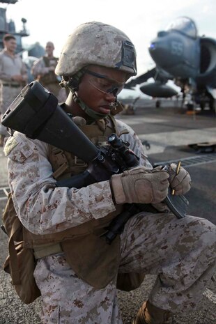 Lance Cpl. Marlon A. Fedd, a rifleman with 1st Platoon, Kilo Company, Battalion Landing Team 3/5, 15th Marine Expeditionary Unit, fillsa magazine before firing at targets during a range held on the flight deck of USS Peleliu, April 6. Fifty Marines of Kilo Company, BLT 3/5, 15th MEU conducted the combat marksmanship program to keep their skills razor sharp. The 15th MEU is comprised of approximately 2,400 Marines and sailors and is deployed as part of the Peleliu Amphibious Ready Group. Together, they provide a forward-deployed, flexible sea-based Marine Air Ground Task Force capable of conducting a wide variety of operations ranging from humanitarian aid to combat. (U.S. Marine Corps photo by Cpl. John Robbart III)