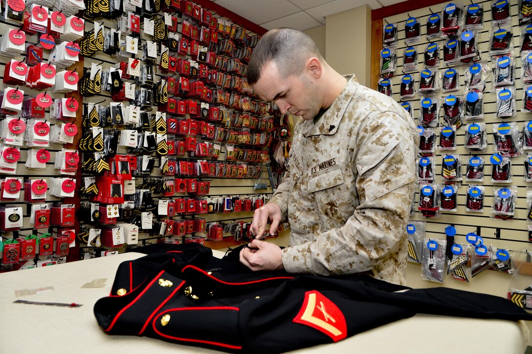 U.S. Marine Corps Cpl. Landon Beaty, Air Force Mortuary Affairs Operations, removes loose threads from a uniform April 2, 2013, on Dover Air Force Base, Del. Beaty assembled the uniform for a fallen Marine who was being sent home. 
