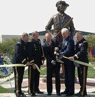 Ohio Gov. Ted Strickland (third from left) cuts the ribbon May 23 to mark the Ohio National Guard monument dedication at Beightler Armory in northwest Columbus. Assisting him are Brig. Gen. Matthew L. Kambic (from left), Ohio assistant adjutant general for Army; Maj. Gen. Gregory L. Wayt, Ohio adjutant general; Maj. Gen. Harry "A.J." Feucht, Ohio assistant adjutant general for Air; and Brig. Gen. Jack E. Lee, Ohio assistant quartermaster general.