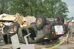 Camp Atterbury Soldiers survey the damage after Tuesday evening's tornado. Showing National Guard resilience, the HUMVEE pictured was later "righted" by Camp Atterbury personnel and driven away.