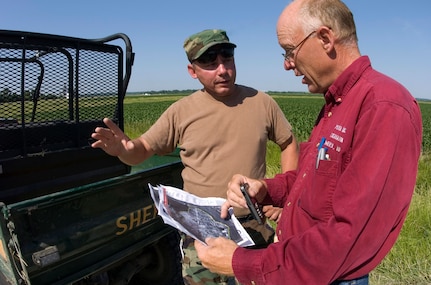 Senior Master Sgt. William Davline speaks with Mike Pieper, the Green Bay Bottom Levee and Draining District chairman, June 18. The town of Green Bay Bottom, Iowa, is in critical condition because it is where the Skunk and Mississippi rivers meet. Approximately 14,000 acres of farmland is in danger of erosion if the flooding is not controlled. Sergeant Davline is Air National Guardsman assigned to the 185th Air Refueling Wing located in Sioux City, Iowa.