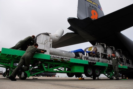 Chief Master Sgt Andy Huneycutt directs C-130 Hercules loadmasters from the North Carolina Air National Guard's 145th Airlift Wing as they load a modular airborne fire fighting system (MAFFS) June 23 at Charlotte, N.C. The guardmembers are fighting wildfires in Northern California.