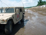 A Missouri National Guard Humvee delivers supplies to Guardmembers working behind it to preserve a Hannibal, Mo., levee on June 22, 2008.