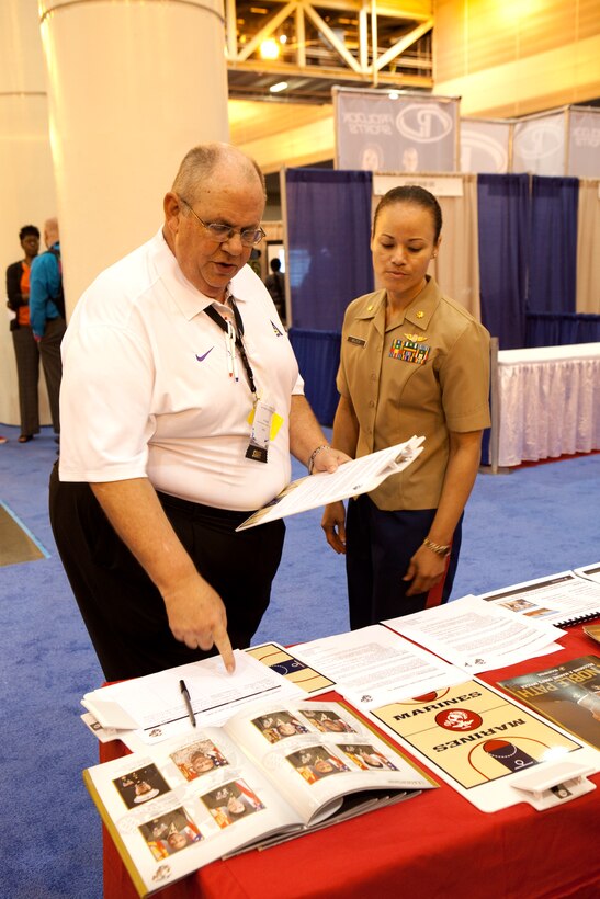 Maj. Karen Walker, of Bay Shore, N.Y., explains how the Marine Corps puts on leadership and training workshops at schools across the country to an interested college coach, here, April 6.  Walker lead the effort at the Women’s Basketball Coaches Association 2013 conference held in conjunction with the NCAA Women’s championship. 