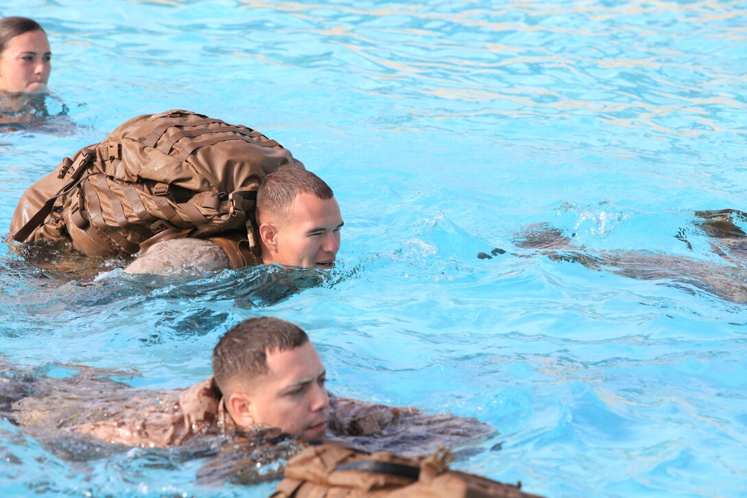 Lance Cpl. Charles Melber, an armory custodian with 9th Communication Battalion, I Marine Expeditionary Force, swims while wearing a full pack during swim qualification at Camp Pendleton, Calif., April 4. The swimming qualification is a required annual training for Marines. Melber, 19, is from Pensacola, Fla.