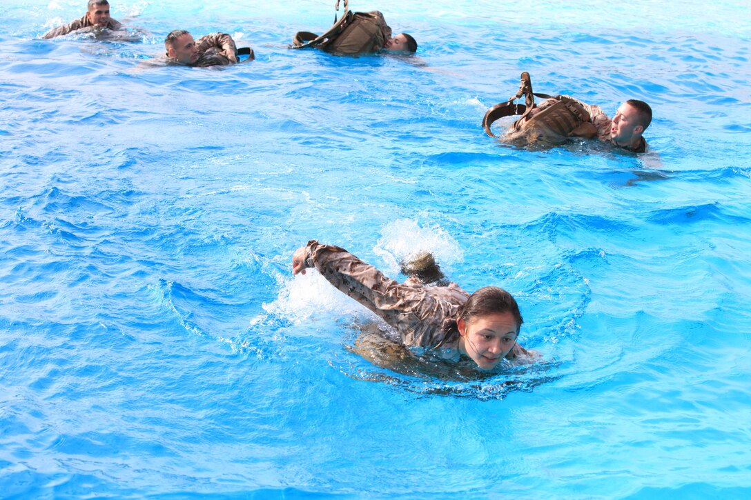 Marines with 9th Communication Battalion, I Marine Expeditionary Force swim across the 43 Area Training Tank with a pack during swim qualification at Camp Pendleton, Calif., April 4. The Marines must swim 25 meters, while wearing a full pack as part of the annual qualification.