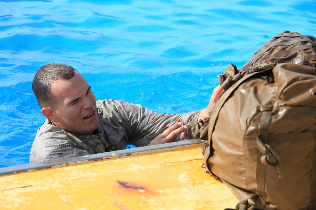 Lance Cpl. Charles Melber, an armory custodian with 9th Communication Battalion, I Marine Expeditionary Force, throws his pack out of the pool during swim qualification at Camp Pendleton, Calif., April 4. The qualification is a required annual training for Marines. Melber, 19, is from Pensacola, Fla.