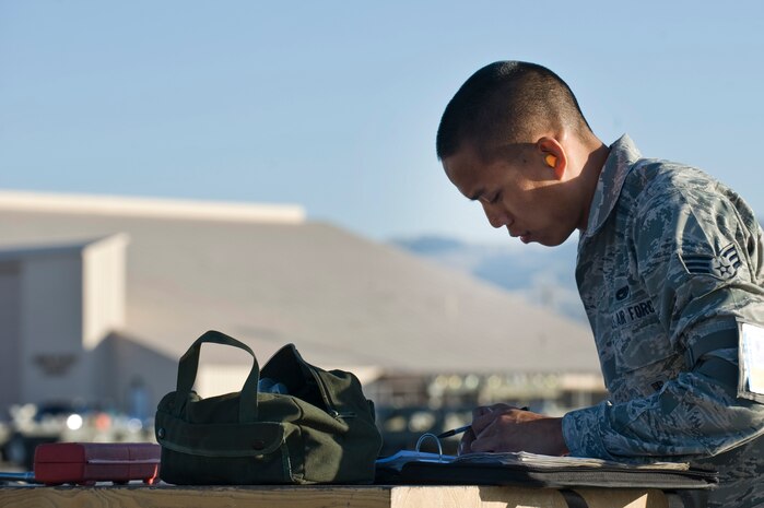 Senior Airman Armin Eusebio, 57th Aircraft Maintenance Squadron aircraft armament systems technician, checks a technical order log during a quarterly load crew competition April 5, 2013, at Nellis Air Force Base, Nev.  Load crew members are selected to participate in the competition by their section chiefs based on overall job performance. (U.S. Air Force Photo by Airman 1st Class Jason Couillard)