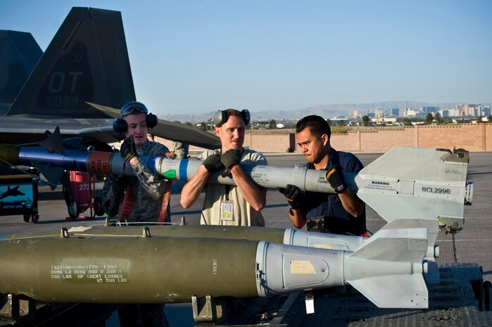 Airman 1st Class David Blyzes, Staff Sgt. Michael Briston, and Senior Airman Constantine Bolo, 57th Aircraft Maintenance Squadron armament systems technicians, lift an AIM-9 Sidewinder missile during a quarterly load crew competition April 5, 2013, at Nellis Air Force Base, Nev. Airmen were tasked to upload munitions to two F-16 Fighting Falcons, three F-15 Eagles, one F-22 Raptor and one A-10 Warthog. (U.S. Air Force Photo by Airman 1st Class Jason Couillard)