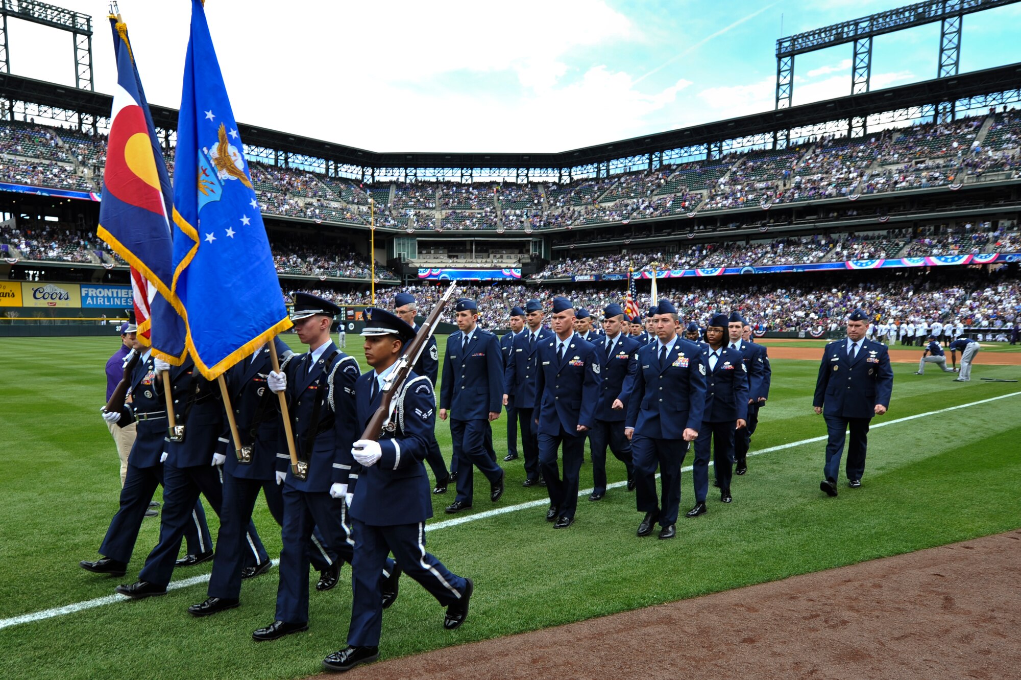 Team Buckley members march during the Colorado Rockies Opening Day ceremony April 5, 2013, at Coors Field, Denver. Service members from all U.S. military branches stood in formations as local law enforcement and fire department members unfurled the flag during the opening day ceremonies. (U.S. Air Force photo by Airman 1st Class Riley Johnson/Released)