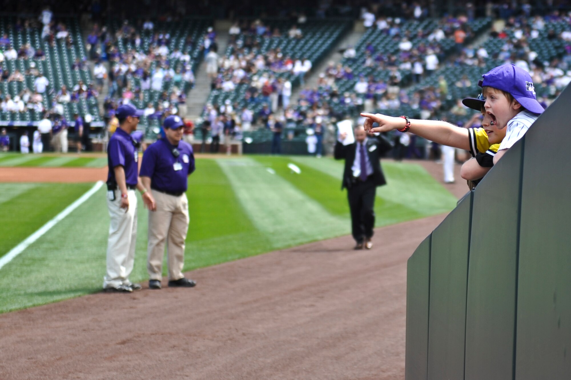 Colorado Rockies fans cheer as U.S. service members march on the field during the Colorado Rockies Opening Day ceremony April 5, 2013, at Coors Field, Denver. Service members from all U.S. military branches stood in formations as local law enforcement and fire department members unfurled the flag during the opening day ceremonies. (U.S. Air Force photo by Airman 1st Class Riley Johnson/Released) 