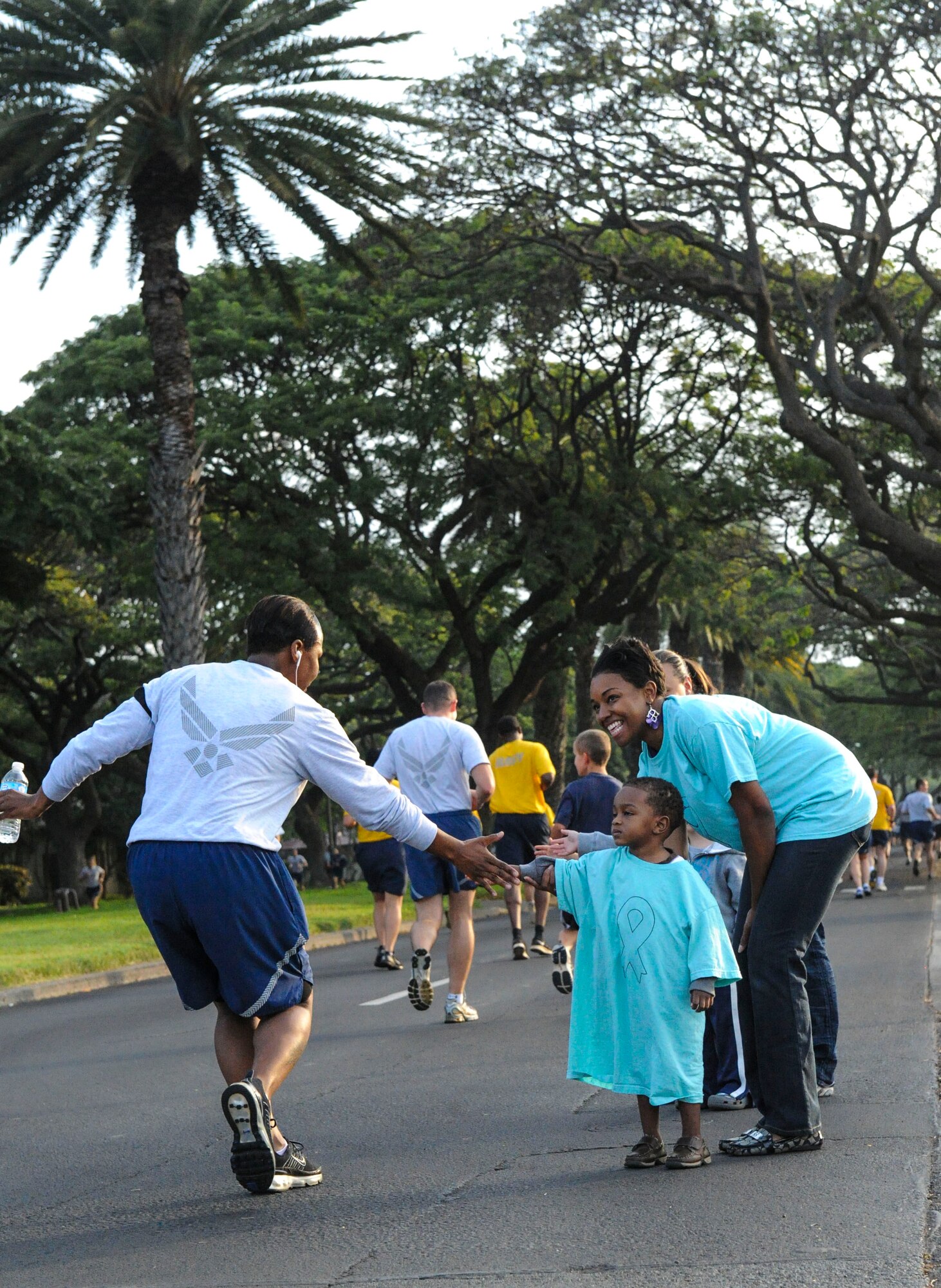 Shari Freeman, Joint Base Pearl Harbor-Hickam Sexual Assault Response Coordinator (Navy), and her son Davis Freeman, 2, encourage runners during the monthly wing fun run at Joint Base Pearl Harbor-Hickam, Hawaii, April 5, 2013. The Sexual Assault Prevention and Response Program reinforces the Department of Defense’s commitment to eliminate incidents of sexual assault through awareness and prevention training, education, victim advocacy, response, reporting and accountability. The Air Force promotes sensitive care and confidential reporting for victims of sexual assault and accountability for those who commit these crimes. (U.S. Air Force photo/Staff Sgt. Terri Paden)