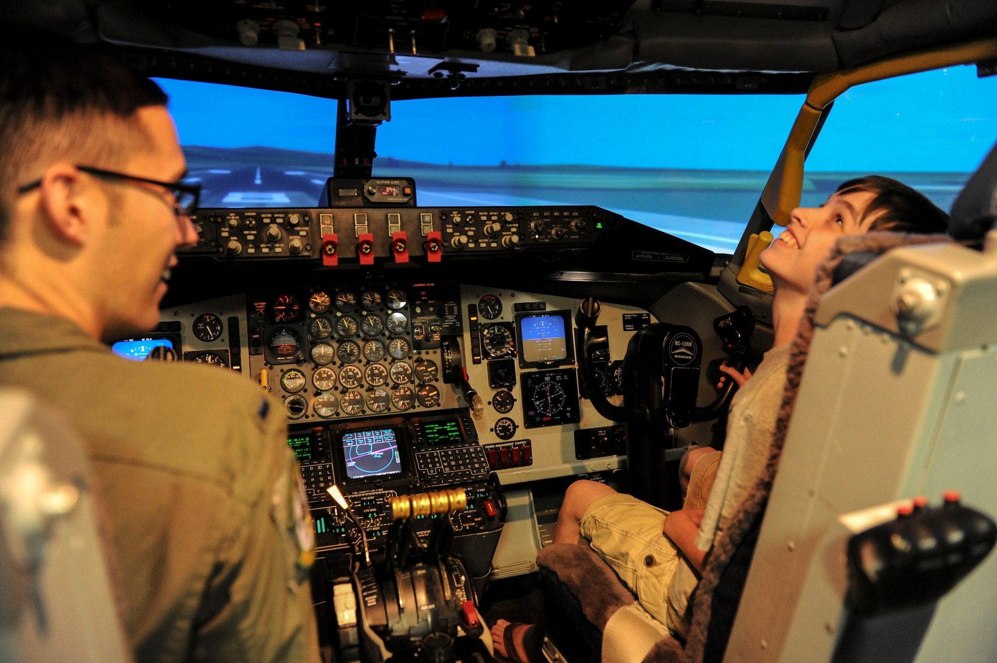 Lt. Dustin Haynes, 96th Air Refueling Squadron, shows off the KC-135 flight simulator to Seth Clifton, who suffers from an acute case of juvenile scleroderma, before his flight at Joint Base Pearl Harbor-Hickam, Hawaii, March 29, 2013. Clifton was invited to test out the simulator while visiting Hawaii as part of his “wish” fulfillment from the Make-a-Wish Foundation. (U.S. Air Force photo/Staff Sgt. Terri Paden)