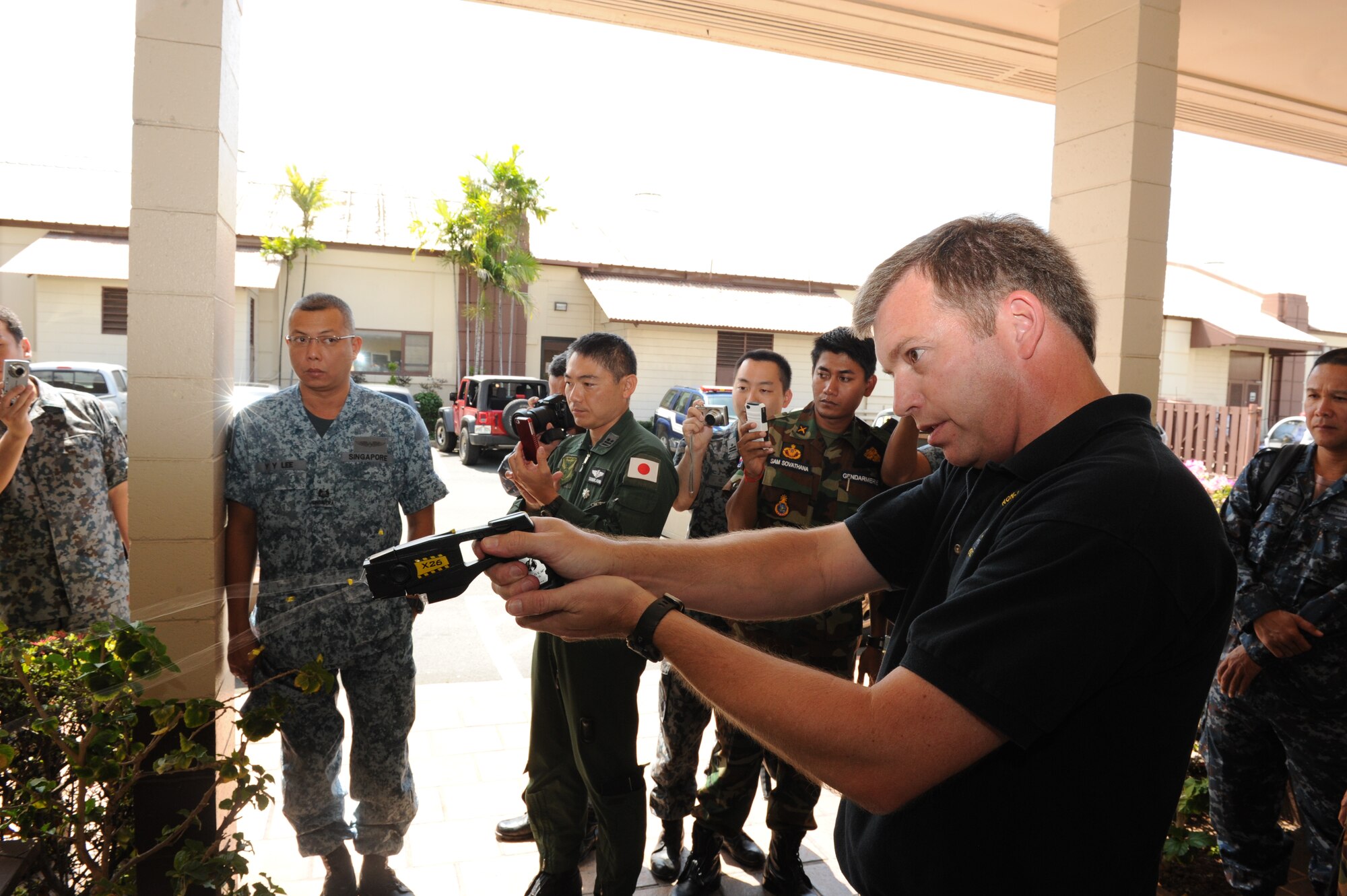 JOINT BASE PEARL HARBOR-HICKAM, Hawaii -- Mr. Larry Brown, U.S. Pacific Command non-lethal weapons program liaison officer, deomonstrates how a taser works to members of the Royal Thai Air Force and Royal New Zealand Army as they participated in a Subject Matter Expert exchange as part of Pacific Unity/Defender April 3, 2013. Members of the Republic of Singapore Air Force, Japan Air Self-Defense Forces, Royal Thai Air Force, Royal New Zealand Army and Royal Cambodian Air Force participated in the exchange, part of U.S. Pacific Command’s Theater Security Cooperation Program, co-hosted by senior civil engineer and security forces personnel from Pacific Air Forces. (U.S. Air Force photo/Master Sgt. Matthew McGovern) 