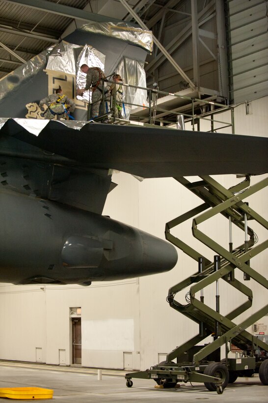 (From left) Staff Sgt. Brian Harrison, Senior Airmen William Moss and Courtney Ramsey, 28th Maintenance Squadron fabrication technicians, replace the tail-flash on a B-1 bomber in preparation for the upcoming wing change of command at Ellsworth Air Force Base, S.D., April 2, 2013. The B-1 will display an “EL” to represent the base designation and “28 BW” indicating it is assigned to the 28th Bomb Wing commander. (U.S. Air Force photo by Airman 1st Class Kate Thornton-Maurer/Released)