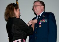 Air Force Reserve Col. (Dr.) Edward Seeliger, the 919th Medical Squadron commander, watches as his wife, retired Air Force Col. Claudia Seeliger, fastens a service pin on his uniform during his retirement ceremony April 7, 2013, at Duke Field, Fla. Among numerous achievements in his 30-year Air Force career that included service as a chief flight surgeon, Seeliger flew on all MC-130E Combat Talon aircrew mission profiles, providing first-hand experience of flight stresses for special operations aircrew. (U.S. Air Force photo/Tech. Sgt. Jasmin Taylor)