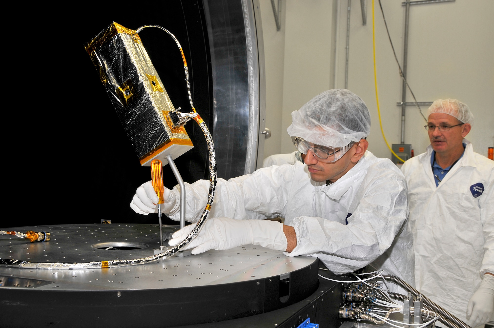 Second Lt. Akshay Tripathi (left), in the AEDC Space and Missile Test division, installs a microsatellite in AEDC’s new Space Threat Assessment Testbed to conduct an initial site acceptance (ISA) test as Marc Smotherman, an ATA space chamber lead, observes. The initial site acceptance test is the equivalent to the halfway point of mission capability. The STAT can simulate a realistic operational environment to space hardware, using multiple source simulators to emulate the conditions existing at various space orbits. The STAT facility will reach Initial Operating Capability in April, followed by Full Operational Capability certification by September 2013. The facility will be operated under the Space Combined Test Force (CTF). (Photo by Jacqueline Cowan)