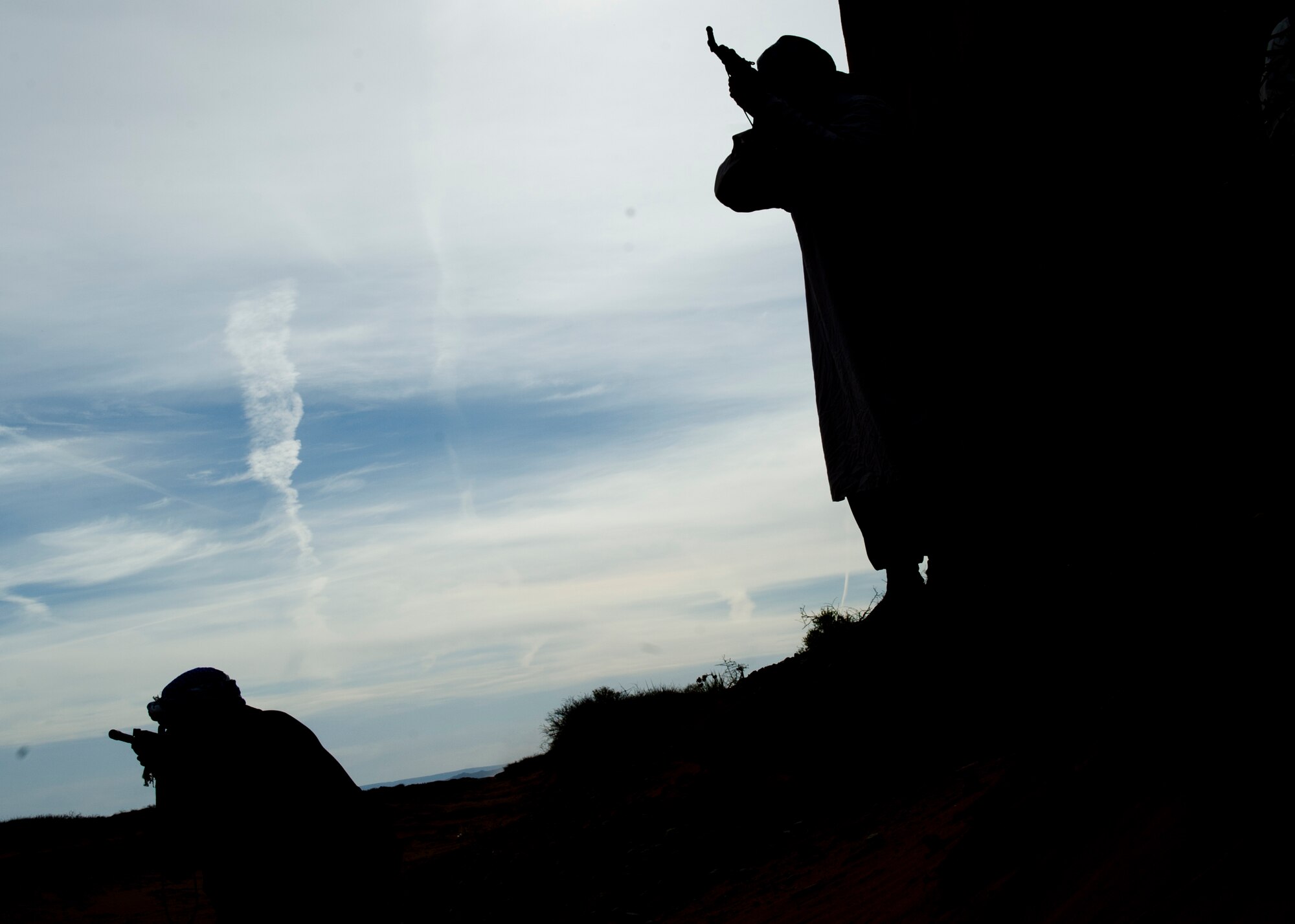 Command Chief Master Sgt. James Patrie and Rally Point Management contractor act as opposing forces during a simulated ground engagement as part of a Remotely Piloted Aircraft training scenario at White Sands Missile Range, N.M., April 5. Col. Andrew Croft, 49th Wing commander, and Chief Patrie were invited to participate in the Rally Point Management scenarios as the opposing force during an RPA training flight with students from Holloman Air Force Base, N.M. Rally Point Management trainers are experts on Joint Terminal Attack Controller (JTAC) and Close Air Support (CAS) procedures as well as ground warfighter equipment and software applications. The opportunity to be a part of the ground training scenarios helped 49th Wing leadership better understand RPA aircrews training experience here at Holloman AFB. (U.S. Air Force photo by Senior Airman DeAndre Curtiss/Released) 