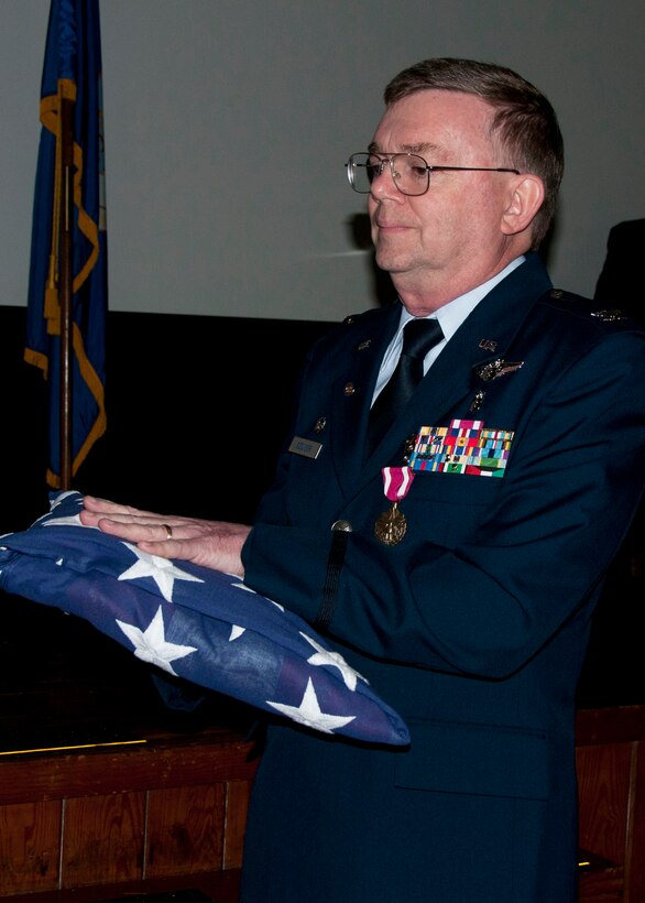 Air Force Reserve Col. (Dr.) Edward Seeliger, the 919th Medical Squadron commander, holds a tri-folded American flag presented to him during his retirement ceremony April 7 at Duke Field, Fla.  Among numerous achievements in his 30-year Air Force career that included service as a chief flight surgeon, Seeliger flew on all MC-130E Combat Talon aircrew mission profiles, providing first-hand experience of flight stresses for special operations aircrew. (U.S. Air Force photo/Tech. Sgt. Jasmin Taylor)